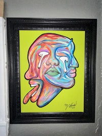 a framed painting of a colorful painting on a wall