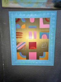 a blue and pink framed painting on a wall
