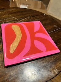 a pink and yellow piece of art on a table